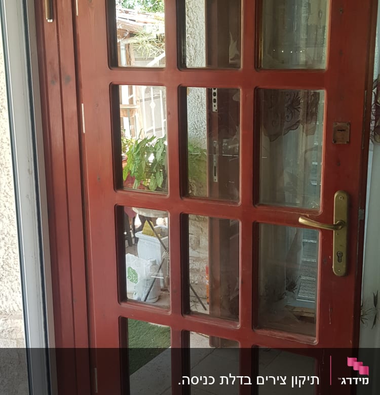 דלת עץ עם חלונות זכוכית ומסגרת אדומה